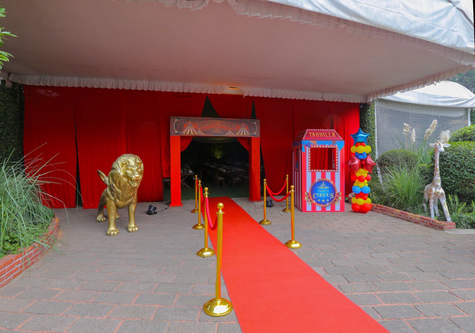 Entrada de circo con alfombra roja y león dorado
