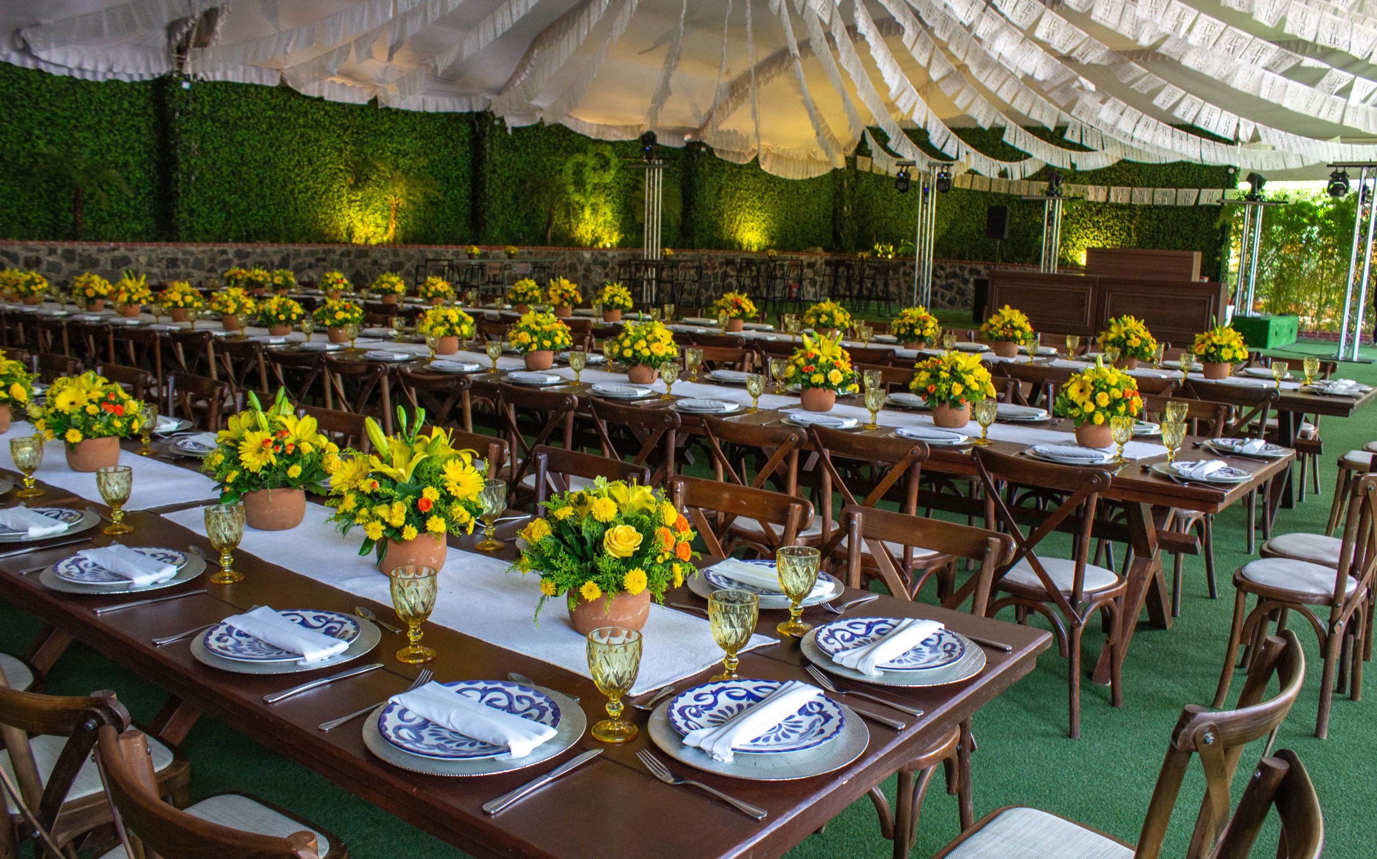 Salón con mesas largas, flores amarillas y vajilla talavera Set & Co